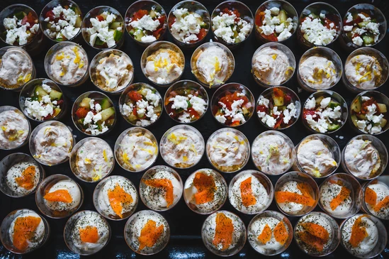 Buffet de réception avec assortiment de canapés et amuse-bouches disposés sur plateaux noirs étagés