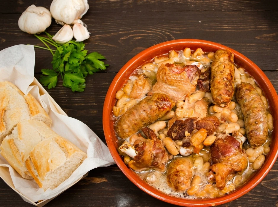 Saucisses grillées artisanales disposées sur planche à découper en bois, accompagnées de moutarde en pot céramique et herbes fraîches, présentation gastronomique professionnelle