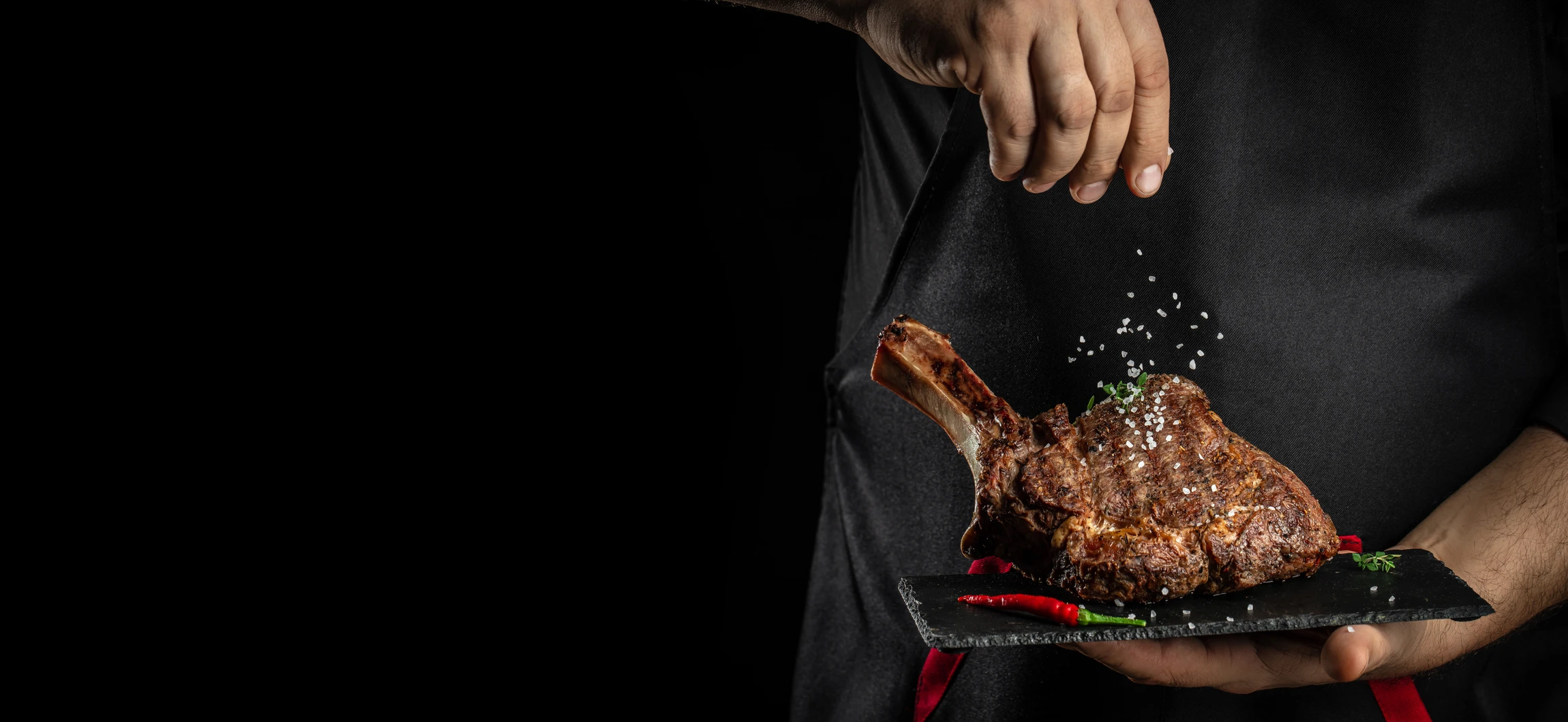 Photographie d'une sélection de viandes fraîches de qualité (côtes, rôtis, steaks) présentée sur un étal de boucherie artisanale avec plateau réfrigéré, montrant des pièces de bœuf, porc et agneau bien présentées, sous un éclairage professionnel qui met en valeur la qualité et la fraîcheur des produits, dans un cadre d'une boucherie traditionnelle de qualité.
