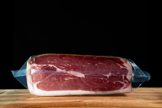 Saucisses grillées artisanales disposées sur planche à découper en bois, accompagnées de moutarde en pot céramique et herbes fraîches, présentation gastronomique professionnelle