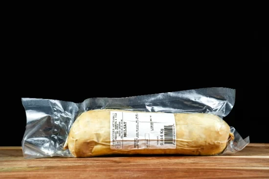 Saucisses grillées artisanales disposées sur planche à découper en bois, accompagnées de moutarde en pot céramique et herbes fraîches, présentation gastronomique professionnelle