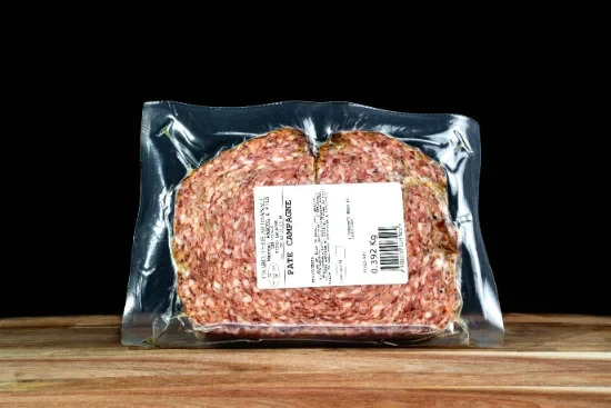 Saucisses grillées artisanales disposées sur planche à découper en bois, accompagnées de moutarde en pot céramique et herbes fraîches, présentation gastronomique professionnelle