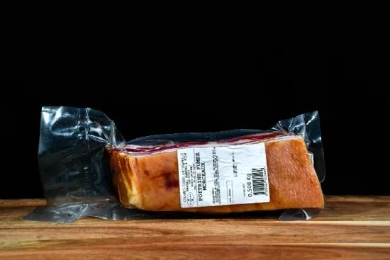 Saucisses grillées artisanales disposées sur planche à découper en bois, accompagnées de moutarde en pot céramique et herbes fraîches, présentation gastronomique professionnelle