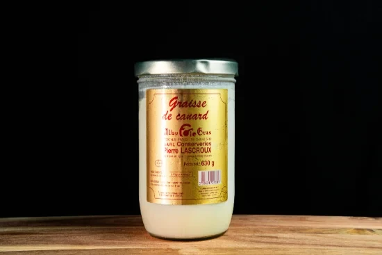 Saucisses grillées artisanales disposées sur planche à découper en bois, accompagnées de moutarde en pot céramique et herbes fraîches, présentation gastronomique professionnelle