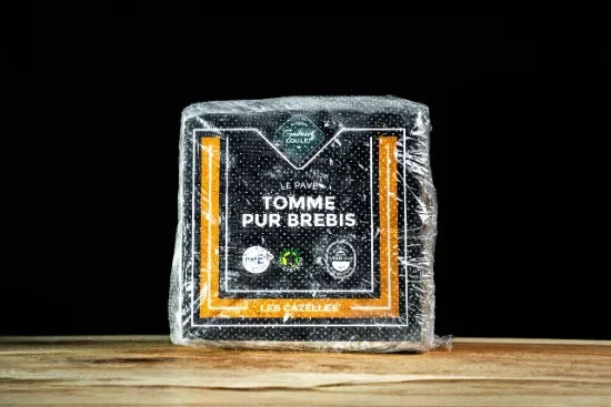 Scène extérieure de découpe artisanale de fromage sur table en bois avec nappe à carreaux rouge et blanc